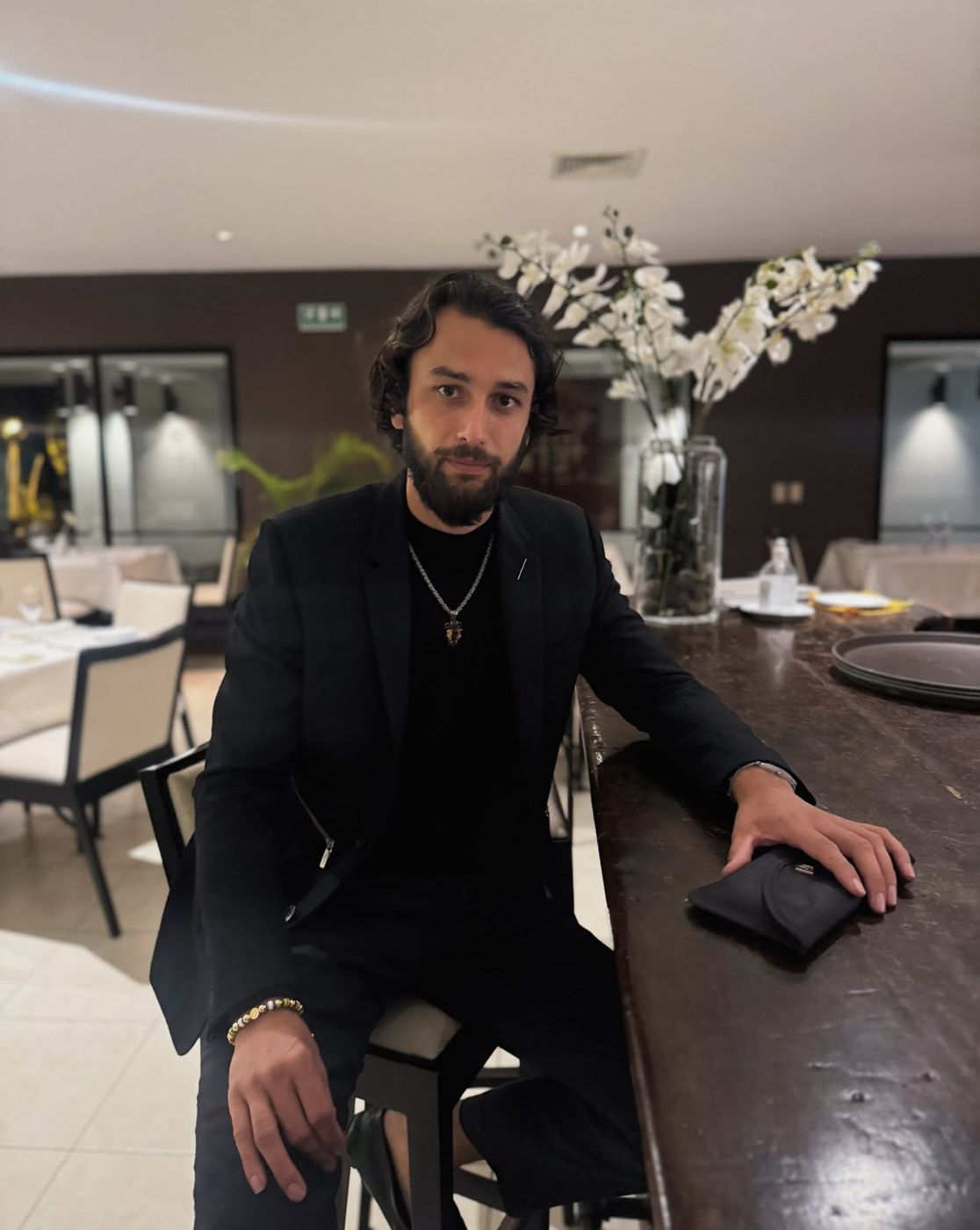 Chris in a black blazer at a restaurant bar in San Salvador